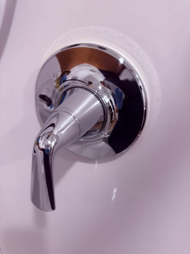 Shiny chrome shower faucet after professional cleaning