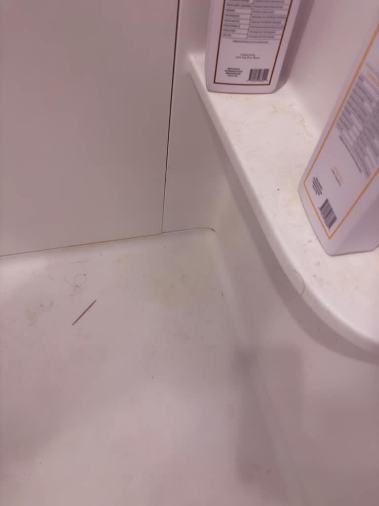Bathtub corner with buildup before cleaning